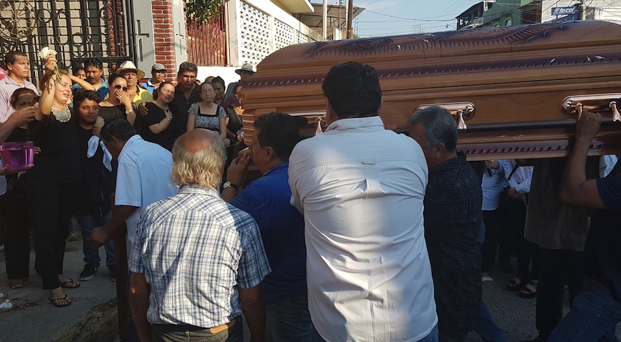 La señora Leticia Rodríguez viuda de Gómez, acompañada de su hijo mayor, despide del santuario de Jesús de Petatlán, el féretro con los restos de su esposo, el alcalde perredista de Petatlán, Arturo Gómez Pérez, asesinado la noche del jueves. Foto: Brenda Escobar