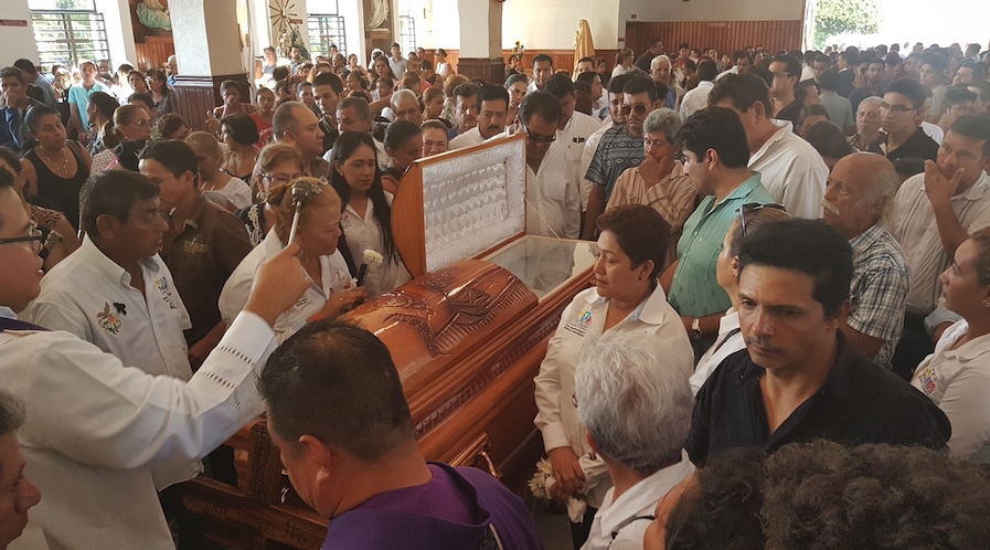 Un sacerdote del santuario de Jesús de Petatlán bendice el féretro con los restos del alcalde perredista, Arturo Gómez Pérez, al término de la misa de cuerpo presente. Foto: Brenda Escobar