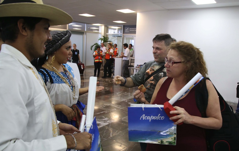 Bienvenida a pasajeros del vuelo inaugural de Montreal, Canadá, a Acapulco, de la empresa Sunwin, tras la llegada al aeropuerto del balneario, donde los 189 viajantes recibieron una copa de mezcal escuchando música de chile frito. Foto: Carlos Alberto Carvajal