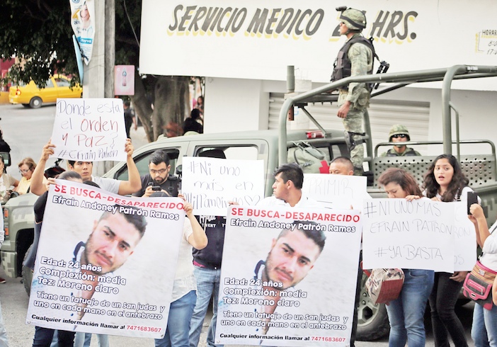Familiares y amigos del joven Efraín Patrón Ramos, quien se encuentra desaparecido desde el 29 de diciembre cuando se lo llevaron en una patrulla de la alameda Granados Maldonado, protestan a las afueras del cuartel de la policía municipal para exigir su aparición con vida. “Vengan ustedes a ordenar aquí, nuestras autoridades no lo hacen”, reclamó en el acto el padre del muchacho. Atrás, policías militares que participaron en la operación de desarme de los preventivos de Chilpancingo . Foto: Jesús Eduardo Guerrero