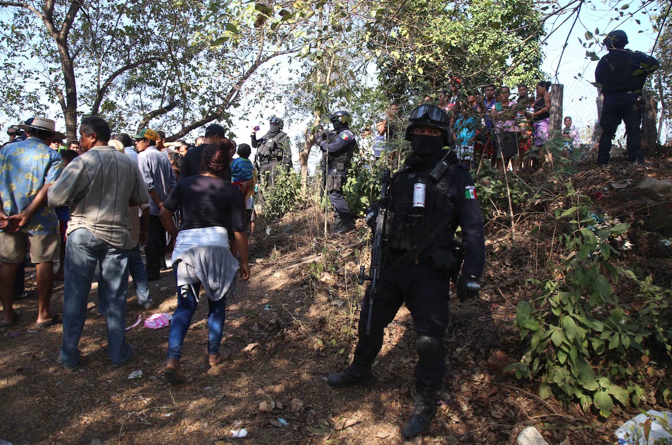 Policías estatales resguardan el sepelio de los seis vecinos de la comunidad de La Concepción, que murieron en el enfrentamiento con policías comunitarios de Los Bienes Comunales de Cacahuatepec el domingo en la madrugada. Foto: Carlos Alberto Carbajal