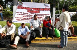 Bloquean maestros jubilados y en activo por horas la Costera; protestan contra el recorte de pensiones