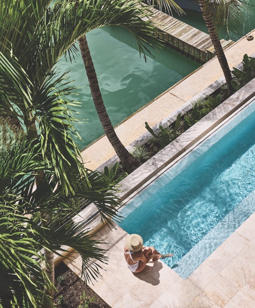 Overhead view of a woman sitting at the pool at Pendry Residences Barbados.