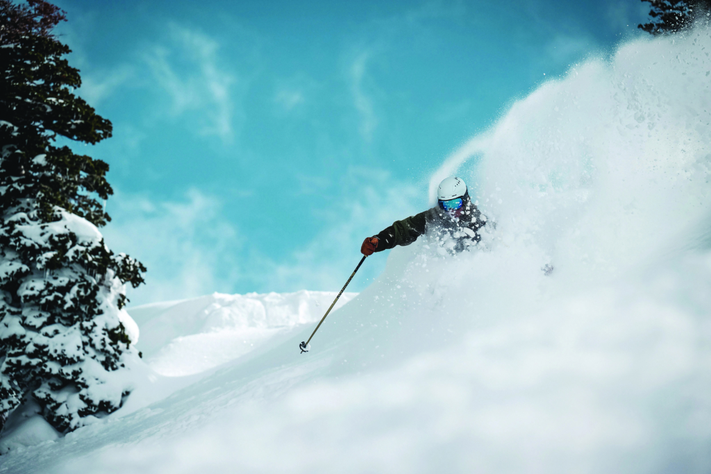 a skier covered in snow coming down a mountain