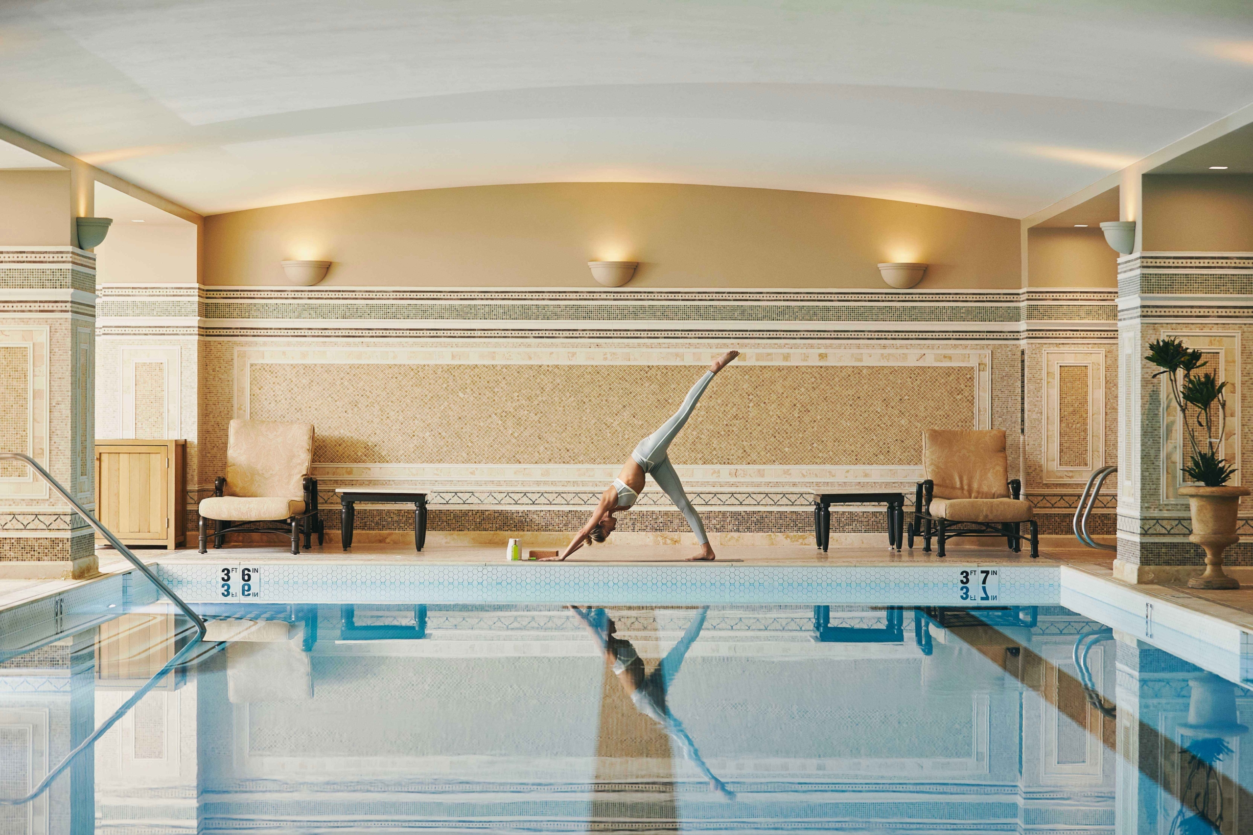 A woman doing yoga by the indoor pool at Montage Deer Valley