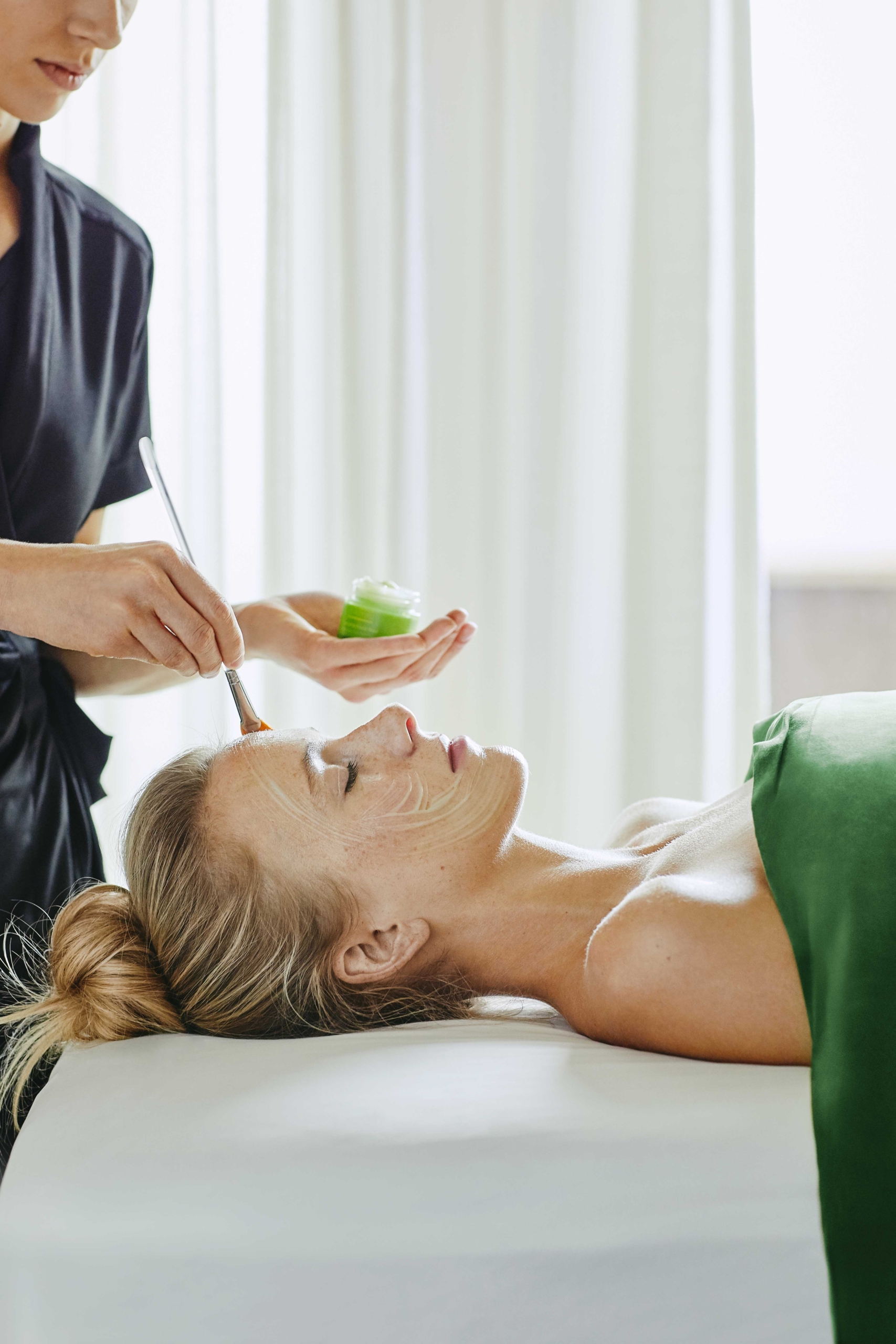 A woman getting a facial at a luxury wellness resort
