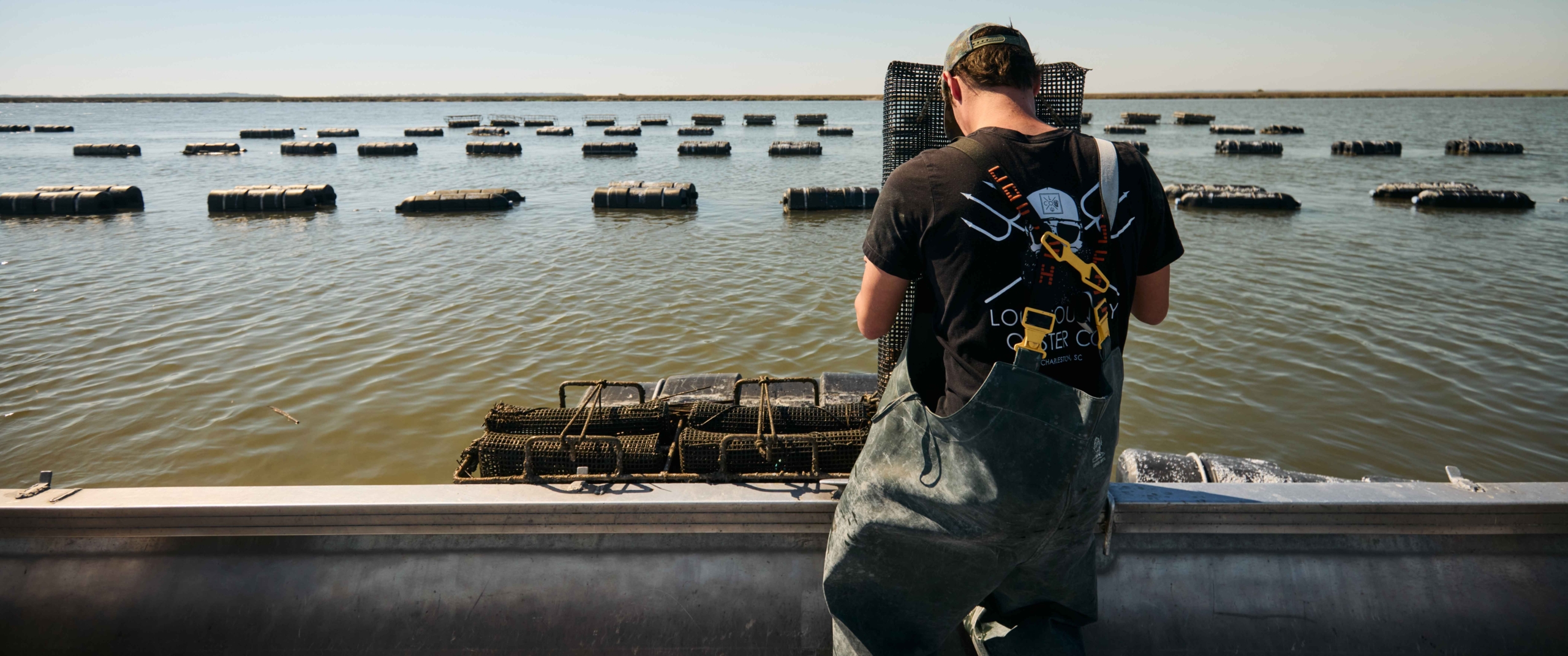 A person cleaning oysters in May River