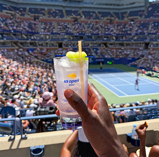 A person holding a drink at the US Open