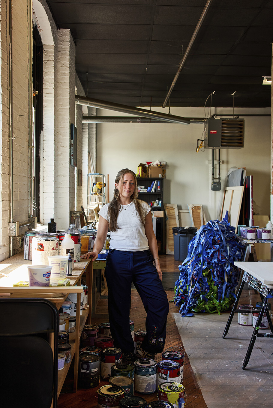 A Baltimore artist sitting next to her easel