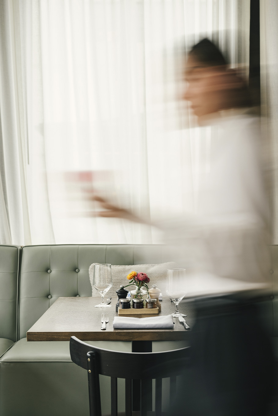 A chef walking through a dining area