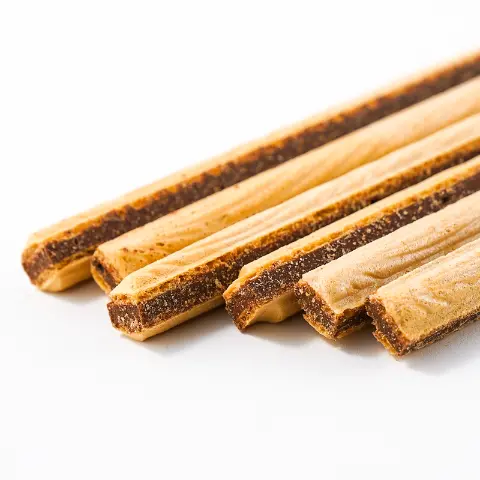 : A close-up of several long, thin wafer or biscuit sticks with a dark chocolate or creamy filling visible along the sides. The light brown sticks are arranged diagonally on a white background.