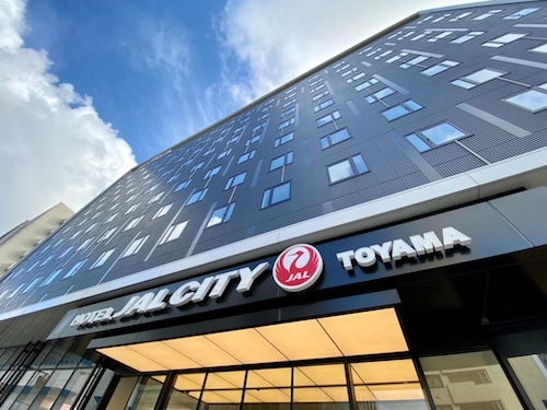 Hotel JAL City Toyama exterior with modern facade and clear blue sky.