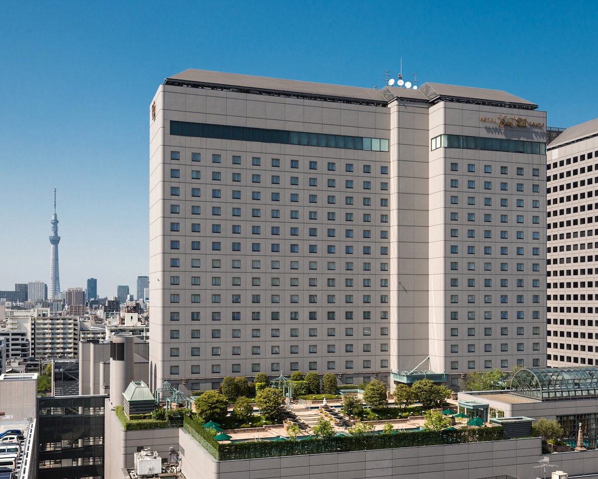 Hotel East 21 Tokyo, a symmetrical high-rise building with a rooftop garden, set against the city skyline with Tokyo Skytree in the background.
