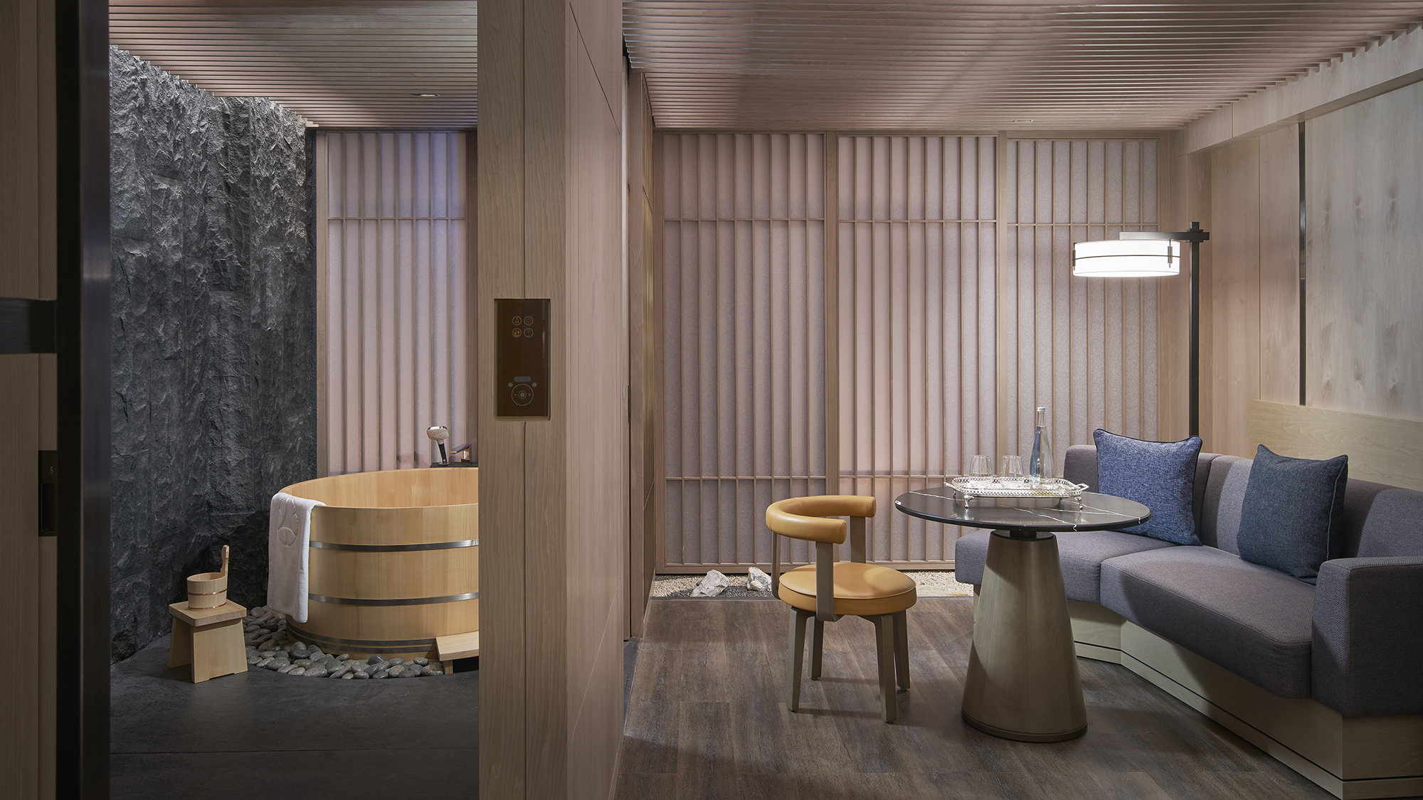 ChatGPT said:
Modern Japanese-style hotel suite with a wooden soaking tub, stone wall, and minimalist living area.