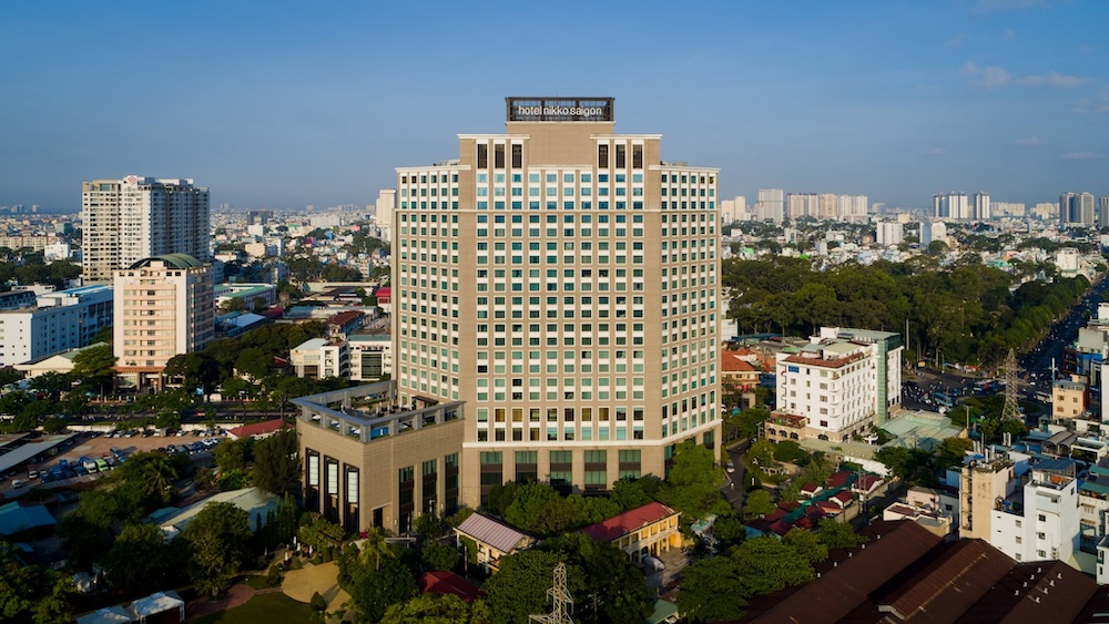 Aerial view of Hotel Nikko Saigon, a modern high-rise surrounded by the bustling cityscape of Ho Chi Minh City.