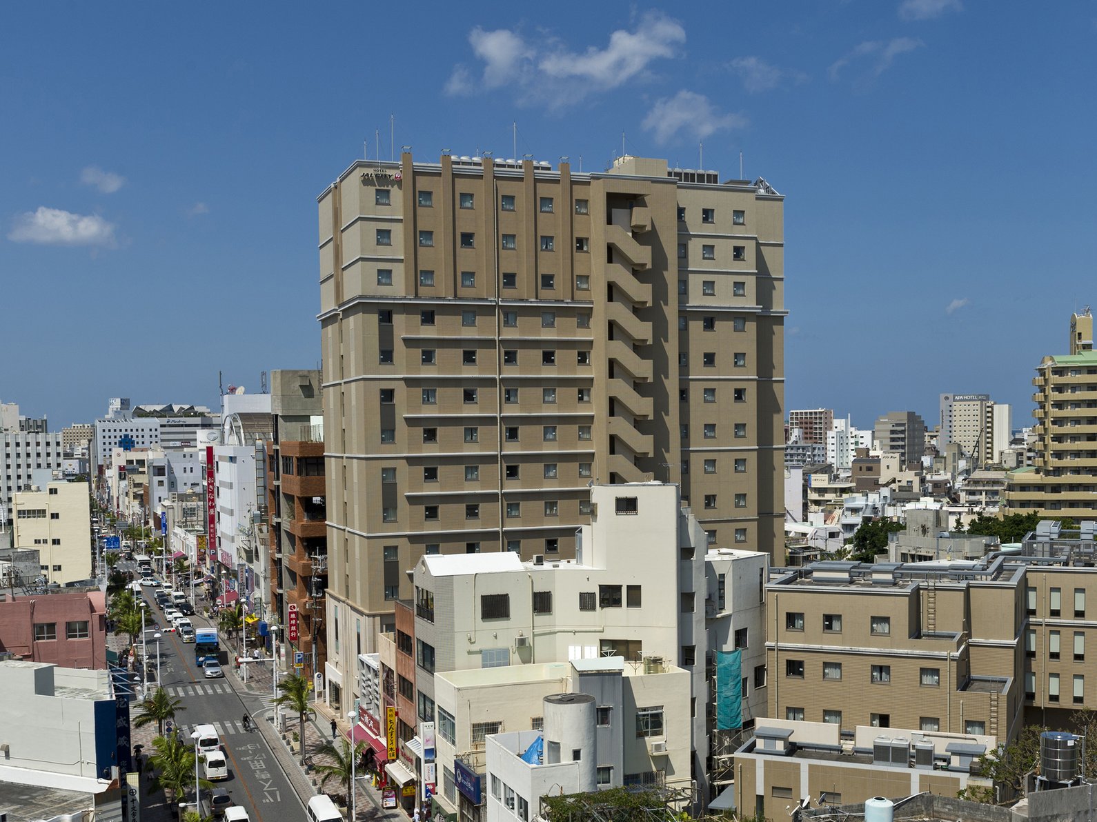 City view of Hotel JAL City Naha under a clear blue sky.