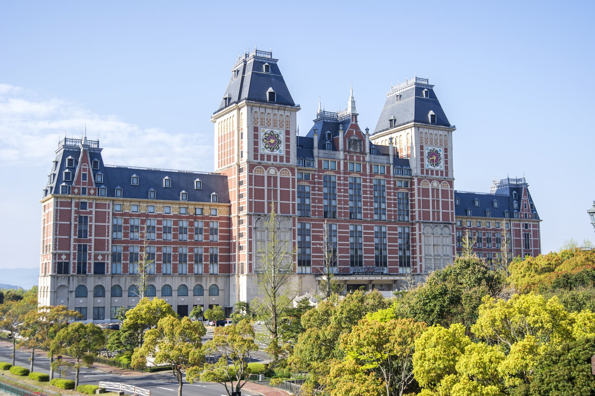 Grand European-style facade of Hotel Okura JR Huis Ten Bosch with clock towers.