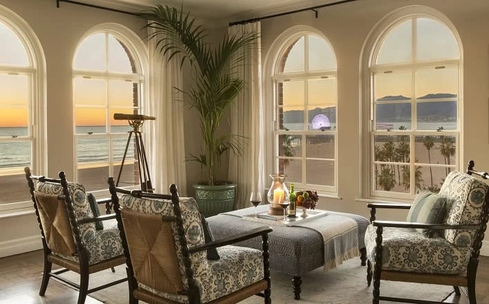 sunset shot of penthouse seating area with windows looking out at the beach