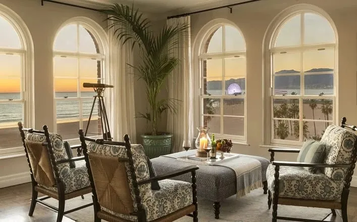 sunset shot of penthouse seating area with windows looking out at the beach