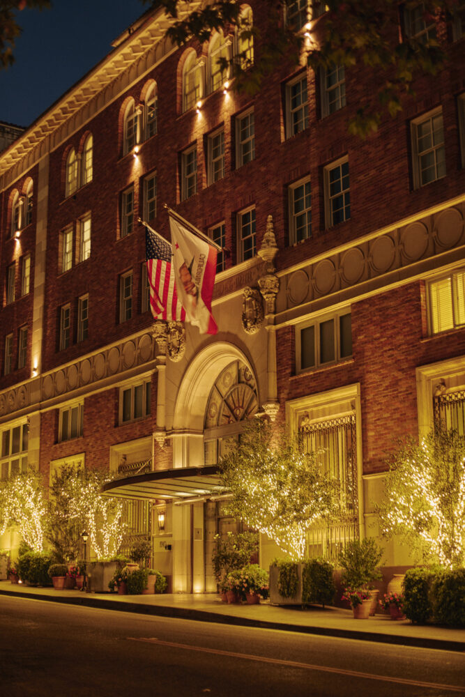 exterior of the hotel at night with the tree lit up