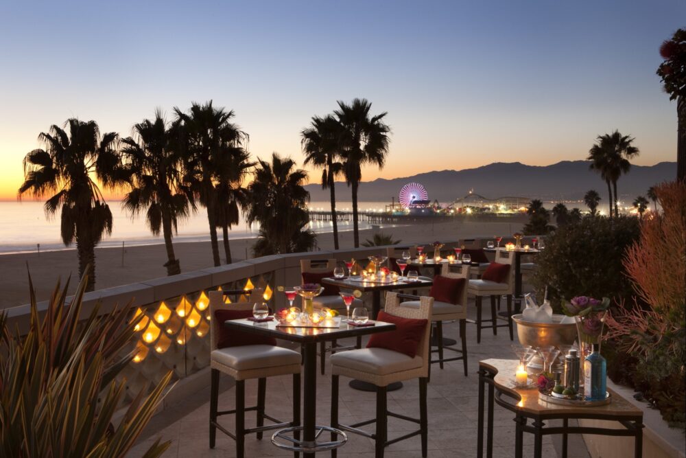 Shutters on the Beach terrace, drinks table, Santa Monica beach and ferris wheel in the background.