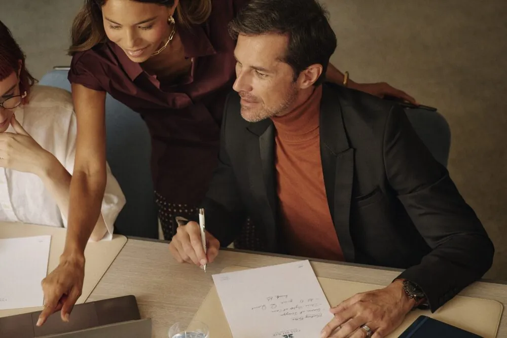 Three professionals review documents in a meeting room at Hotel Casa del Mar.