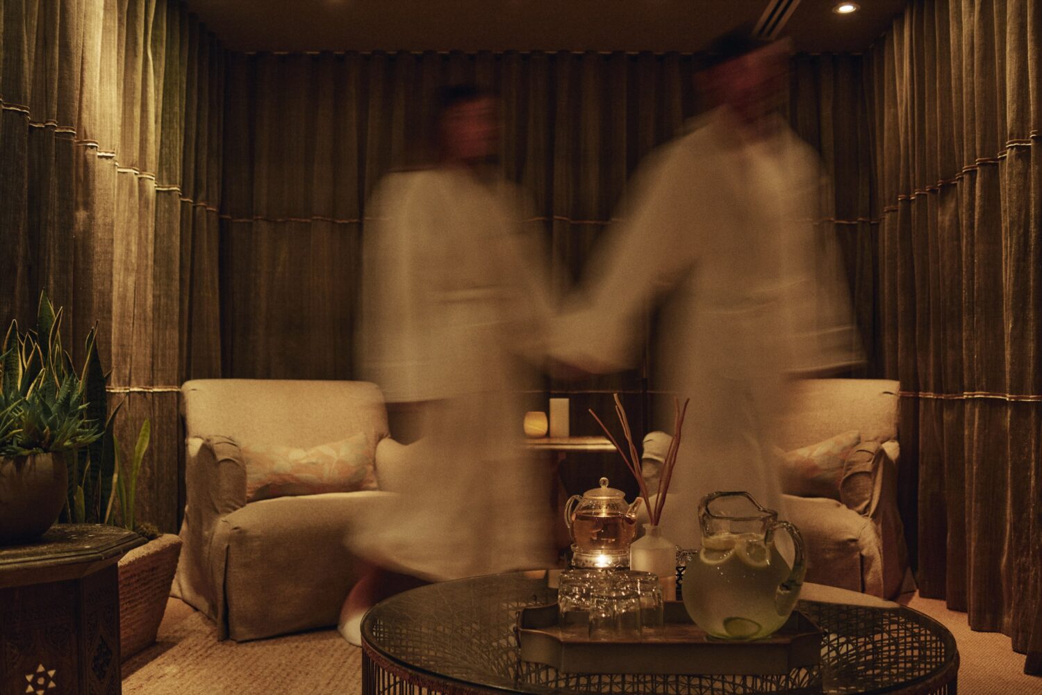 man and woman out of focus, wearing robes and walking out of the frame in the hotel spa's sitting room