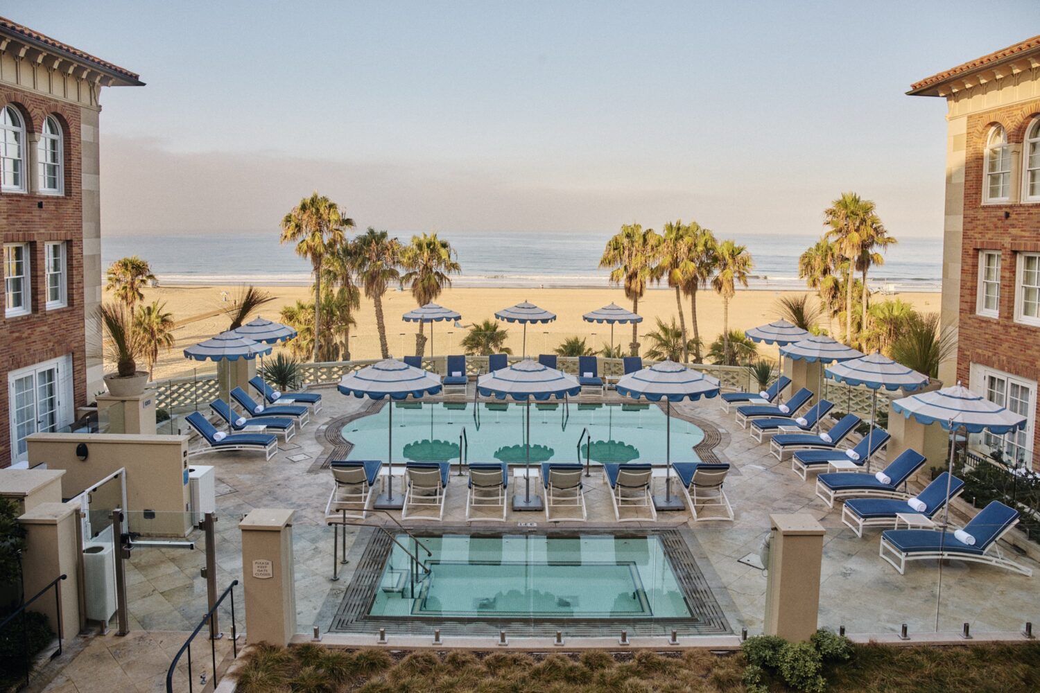Casa del Mar pool, hot tub and beach view with palm trees between the buildings