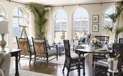 A hotel in Santa Monica with arched windows, ocean view, and wicker furniture.