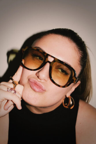 Sophia Dion close up shot wearing sunglasses and has pursed lips