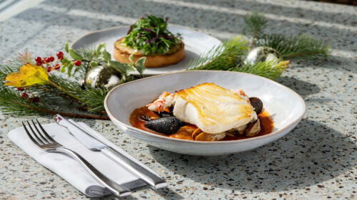 muscles and fish dish paired with a bread with greenery on top