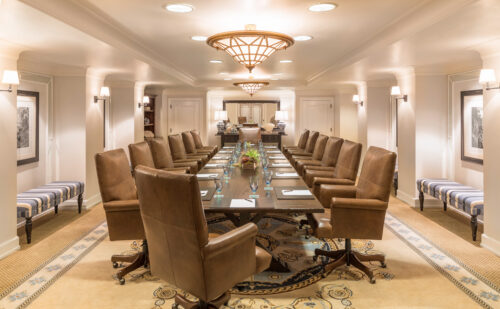 Elegant meeting room in Santa Monica with long wooden table and brown leather chairs.