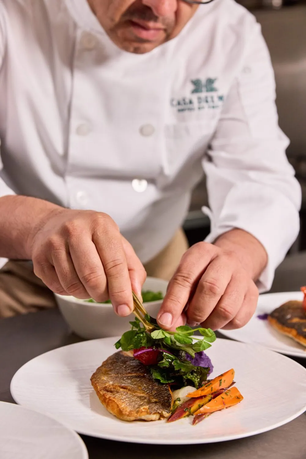 Executive Chef plating a dish for an event at Hotel Casa del Mar.