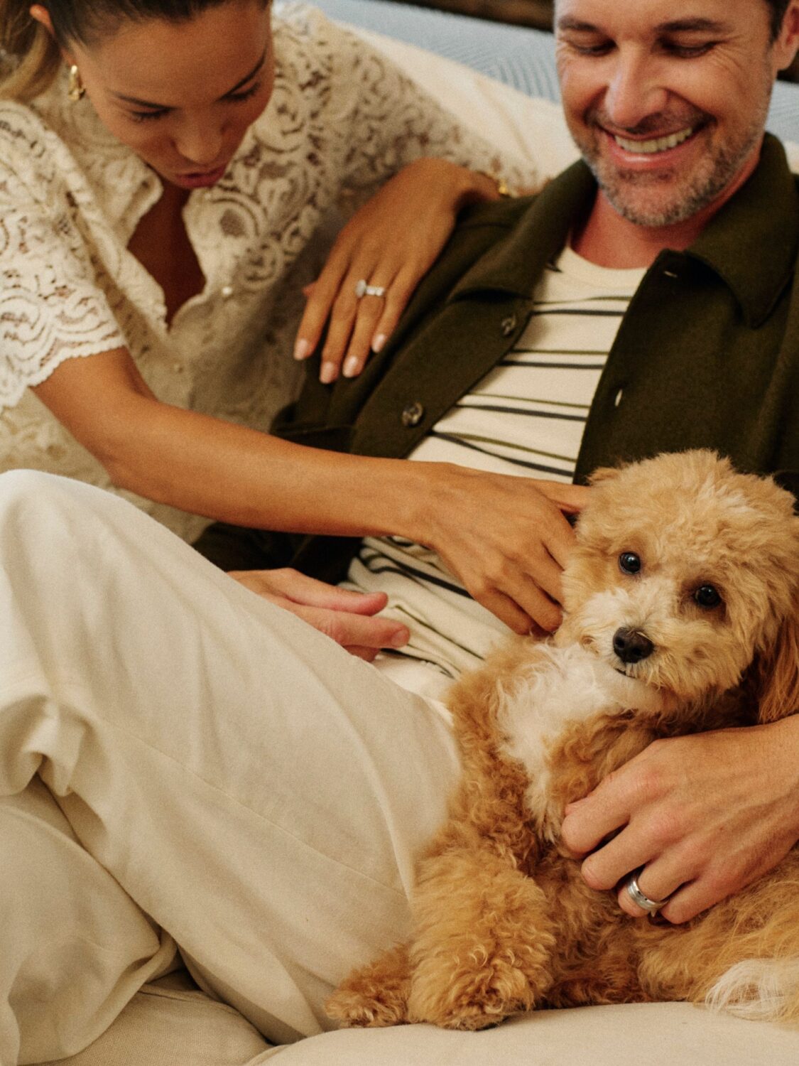 A couple sitting with their dog on the couch