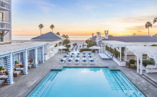ariel view of the shutters pool with palm trees and the sunset/beach in the background