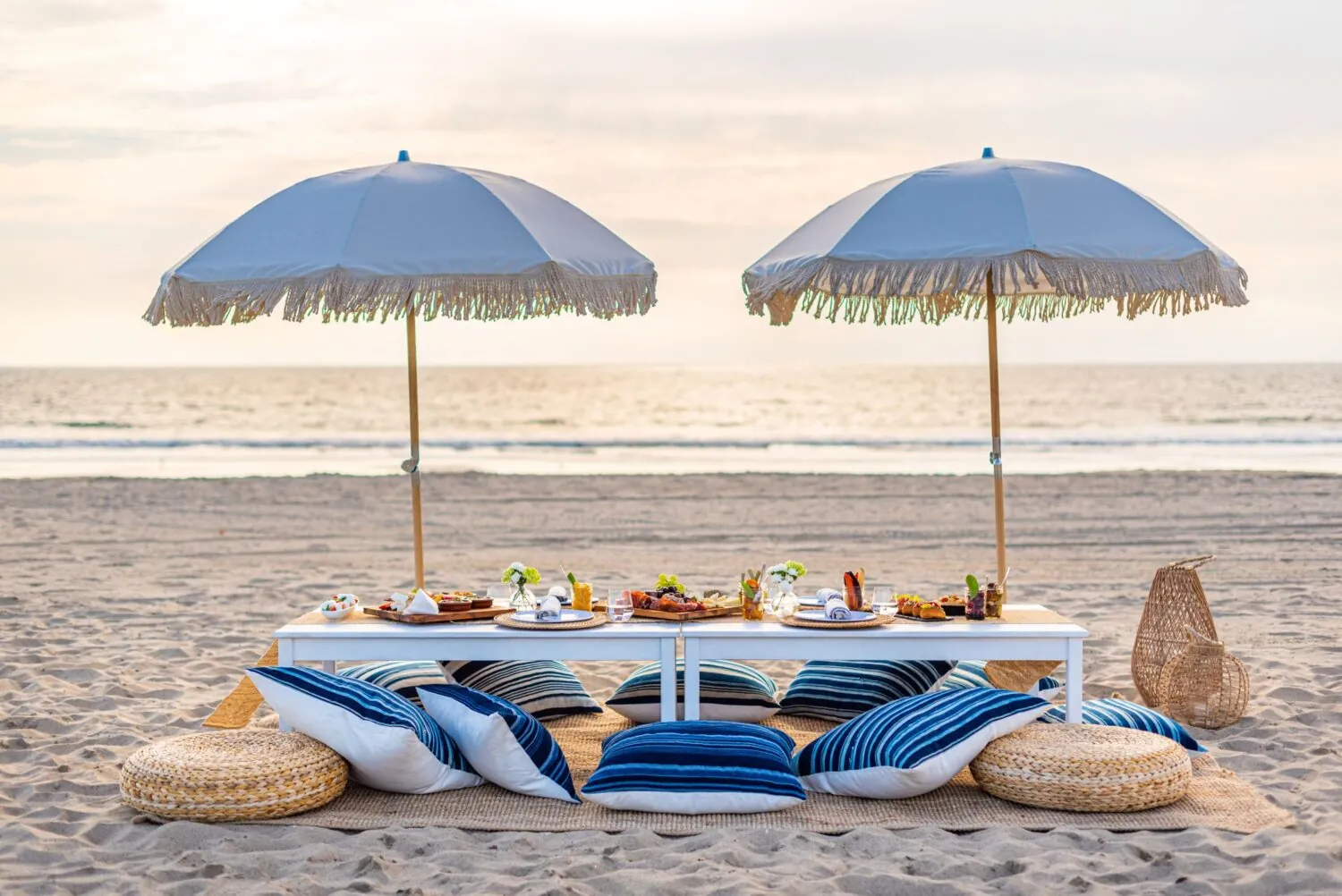 beautiful beach picnic with umbrellas and blue & white pillows