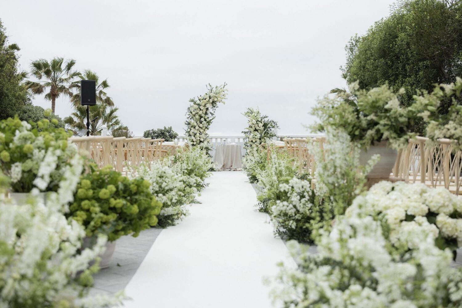 Beautiful outdoor wedding ceremony setup with floral arrangements and a scenic ocean view.