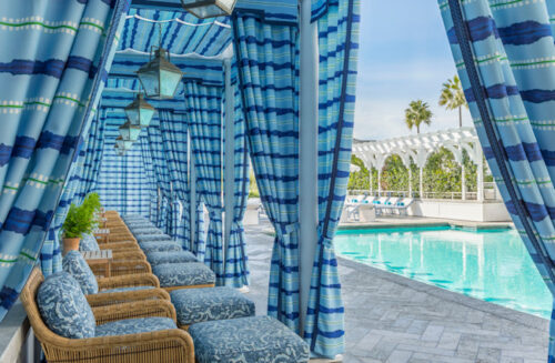 pool cabanas with blue stripped curtains and the pool
