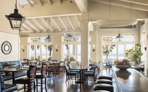 1 Pico, Shutters beachfront restaurant, with wooden tables, bar seating, and large windows.