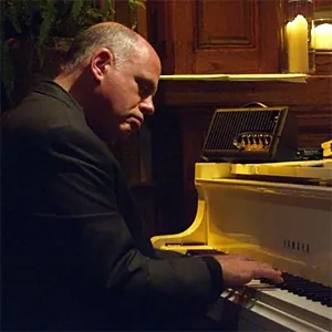 Stuart Elster profile shot playing the piano