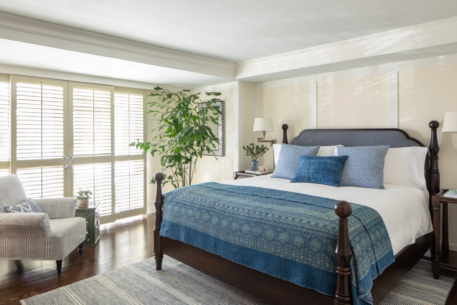 Cozy bedroom with blue tones, wooden bed, soft lighting, and coastal decor for a relaxing vibe.