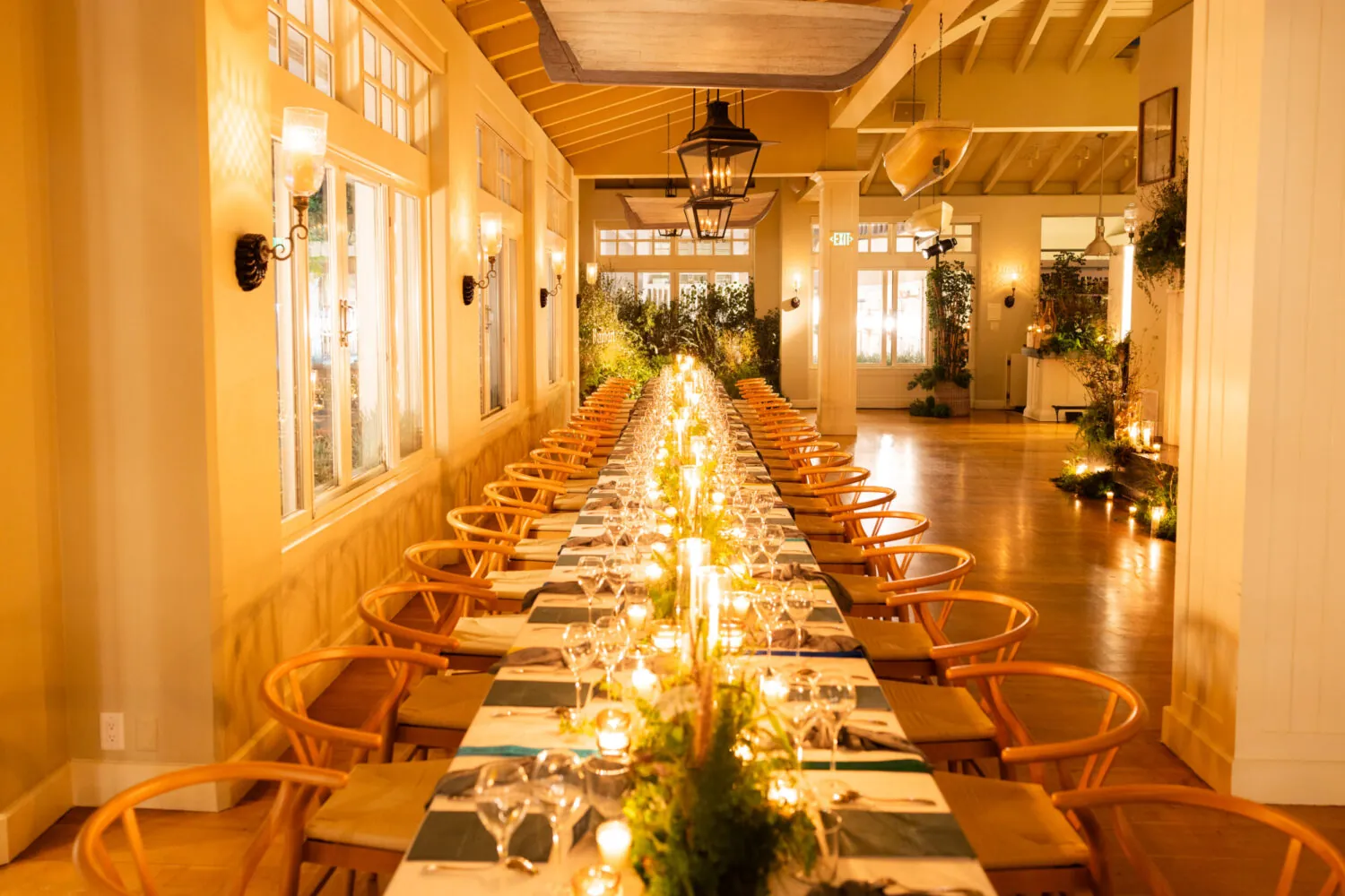 A banquet table set with candles, greenery, and wooden chairs at 1 Pico restaurant in Santa Monica.