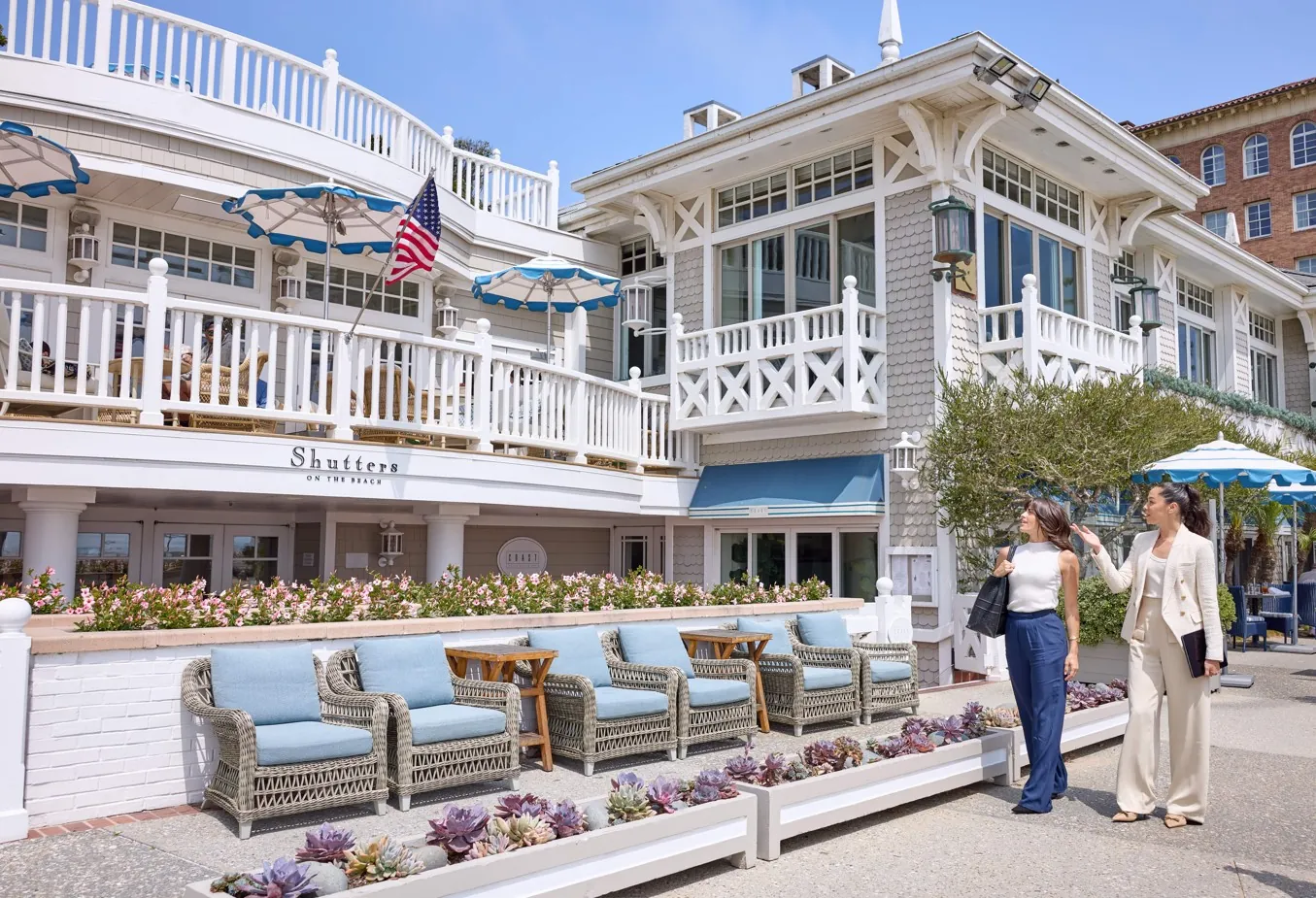 Two people conversing outside Shutters on the Beach, a luxury hotel in Santa Monica.