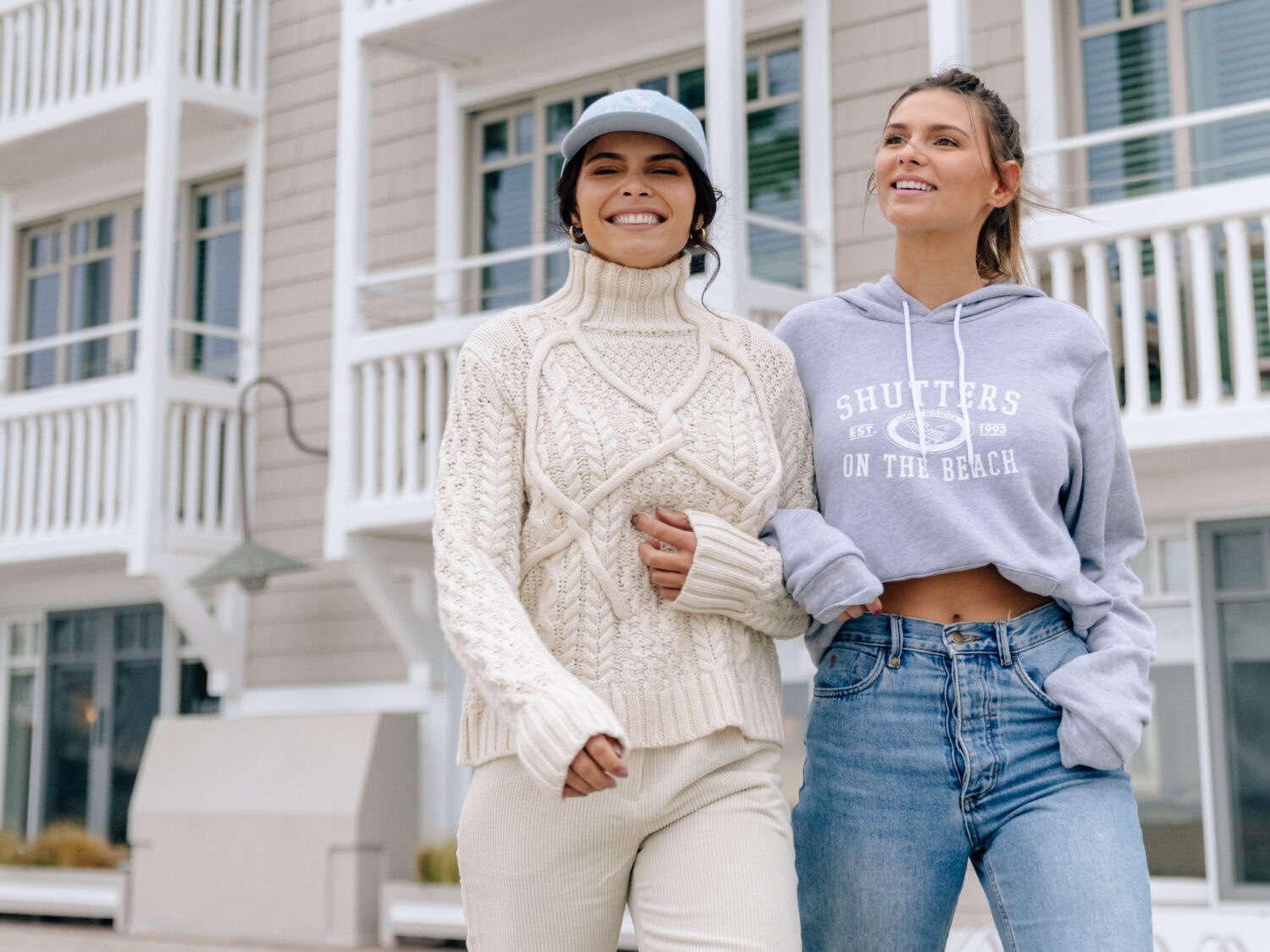 Two girls walking on the santa monica strand in front of shutters