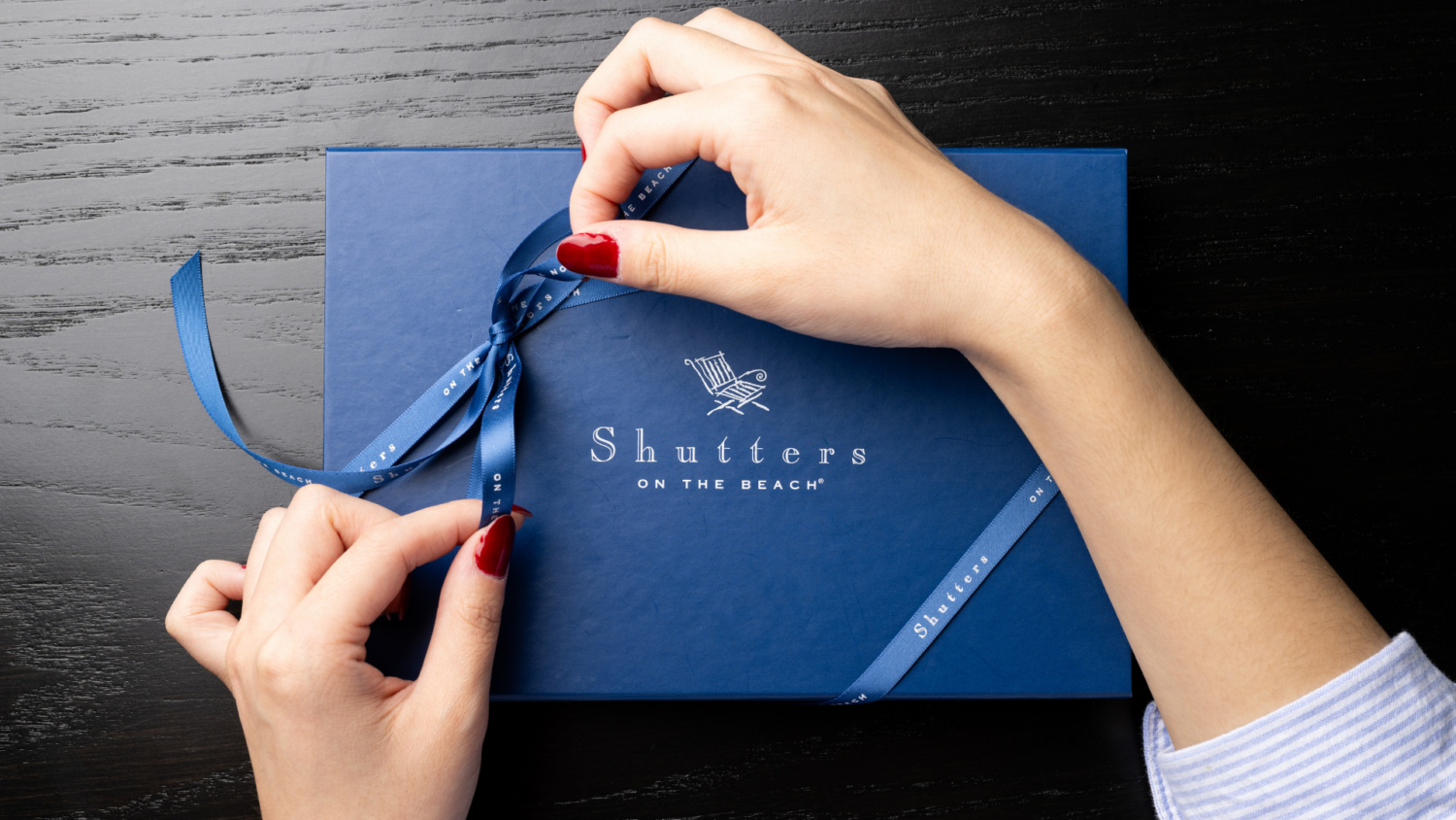 shutters on the beach gift card box being tied with ribbon