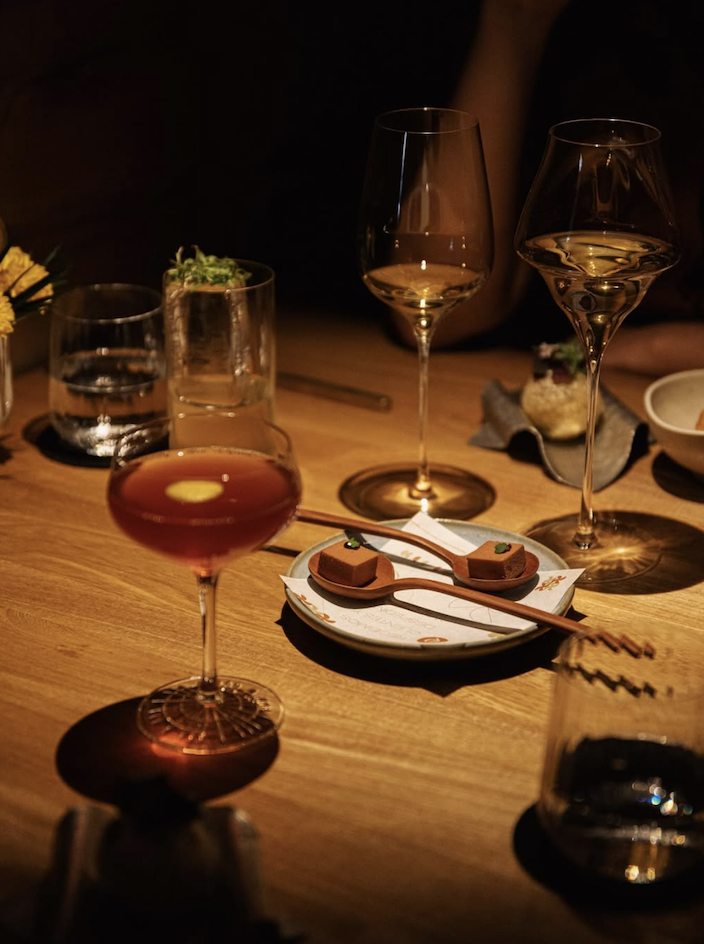 A table at Pendry Residences Mexico City with cocktail and wine glasses.