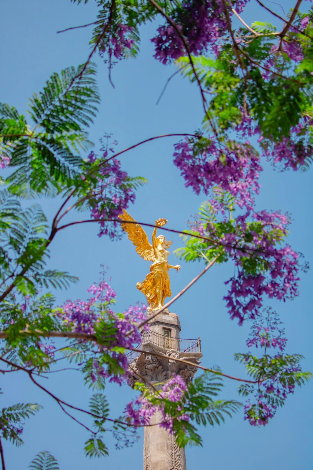 A statue surrounded by purple flowers near Pendry Residences Mexico City.