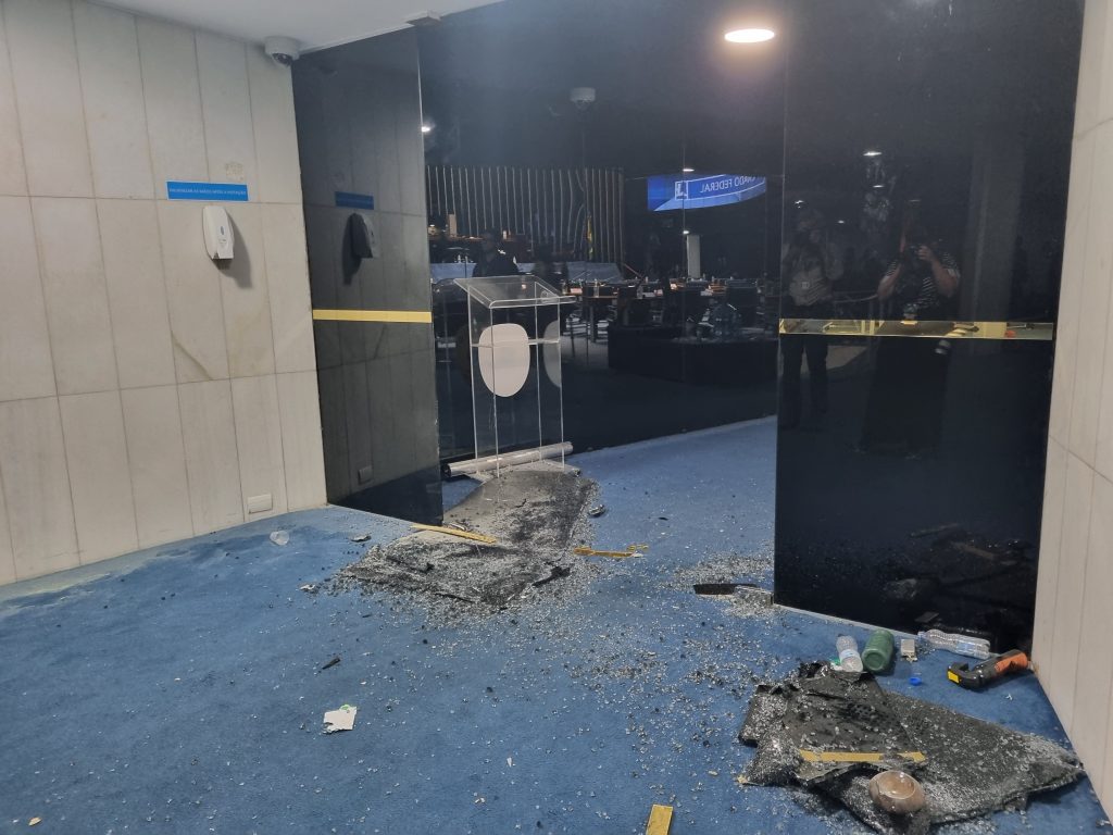 As portas de entrada do plenário do Senado Federal foram depredadas e os estilhaços de vidro ficaram espalhados pelo chão.