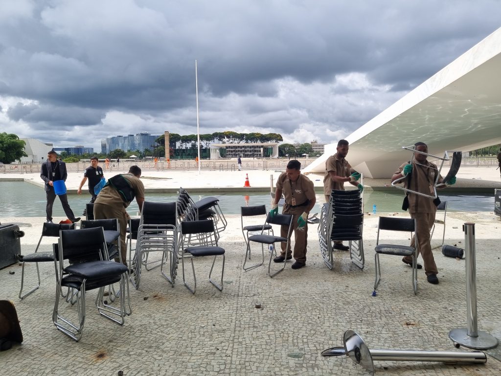 Funcionários recolhem cadeiras do Salão Nobre do Palácio do Planalto que foram atiradas pela varanda e pelas vidraças.