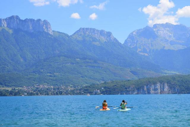 Teen travelers doing water sports in Alps on summer adventure tour